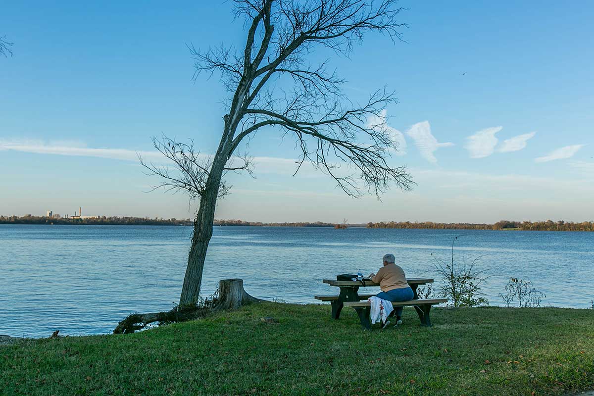 Person sitting on bench in front of water in Hopewell, VA